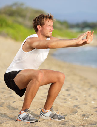 outdoor exercise man doing squats on the beach